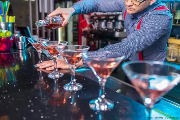 Barkeeper füllt Likör in Gläser - In diesem Beitrag erfahren Sie, warum Gin so beliebt ist und welches die beliebtesten Gin Tasting Angebote im Web sind.
